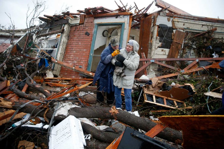 Pam Russell left and Linda Hart rescue Pam's cat Larue from Russell's house a day after a tornado hit on Delta Drive in Rowlett Texas Sunday Dec. 27 2015. At least 11 people died and dozens were injured in apparently strong tornadoes that swept