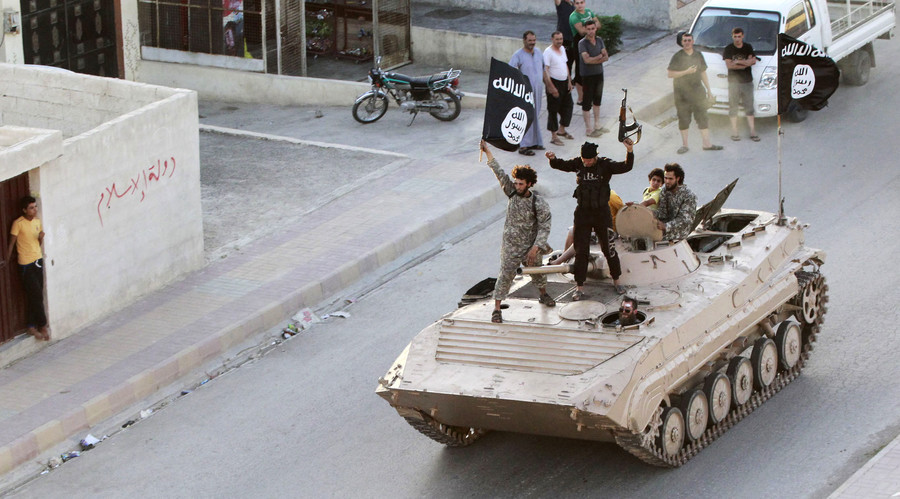 Militant Islamist fighters take part in a military parade along the streets of northern Raqqa province