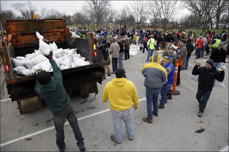 Volunteers form a human chain as they help load sandbags today in St. Louis. Flooding across Missouri has forced the closure of hundreds of roads and threatened homes