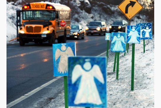 A bus traveling from Newtown Conn. to Monroe stops in front of 26 angels along the roadside on the first day of classes for Sandy Hook Elementary School students since the Dec. 14 shooting in Monroe Conn. Thursday Jan. 3 2013