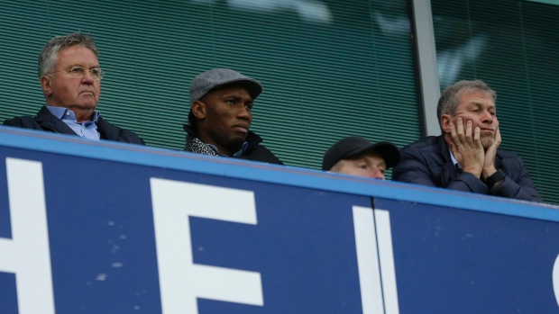 Chelsea's new manager Guus Hiddink left sits next to former Chelsea player Didier Drogba center and club owner Roman Abramovich right before the English Premier League soccer match between Chelsea and Sunderland at Stamford Bridge stadium in Lon