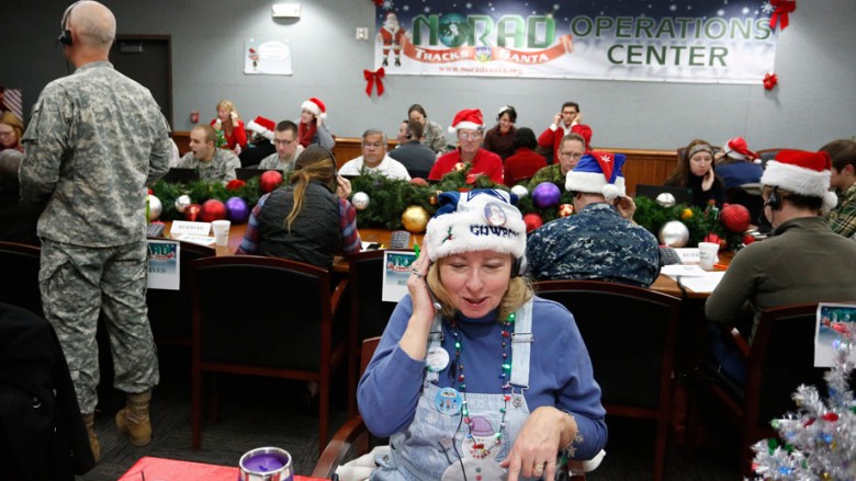 Patty Shook takes a phone call from a child asking where Santa is and when he will deliver presents to her home inside a phone-in center during the annual NORAD Tracks Santa Operation at the North American Aerospace Defense Command at Peterson Air Forc