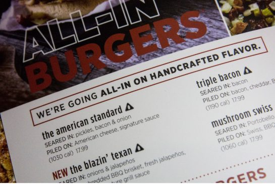 The logo of a salt shaker in a triangle meant to warn consumers of high sodium content in food appears on an Applebees menu in New York City. The new sodium warning is the result of a city-wide law aimed at reducing salt consumption