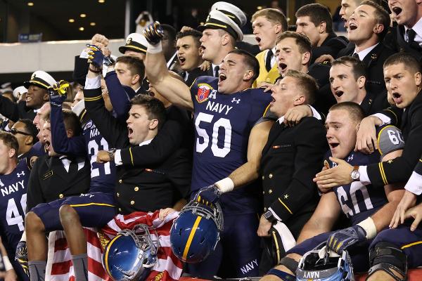 Navy football players celebrate after defeating Army in the annual rivalry for the 14th time in a row. The game was a thriller that saw The Black Knights ahead of The Midshipmen at halftime