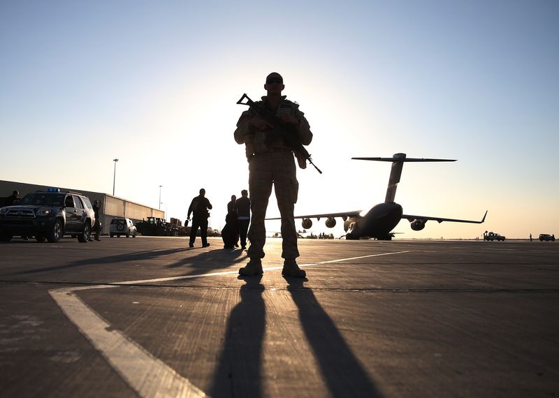 A soldier stands guard near a C17 military aircraft sitting on the tarmac
