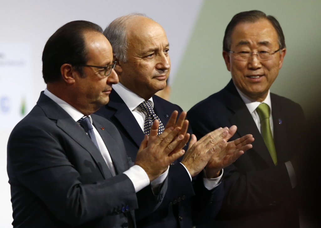 French President Francois Hollande left French foreign minister Laurent Fabius center and United Nations Secretary General Ban Ki-moon applaud at the COP21 the United Nations Climate Change Conference in Le Bourget north of Paris Saturday Dec.12