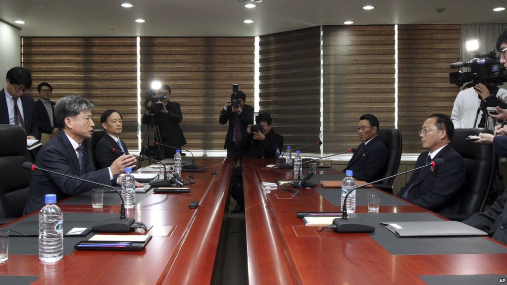 Hwang Boogi left South Korea's vice minister of unification and the head negotiator for high-level talks with North Korea talks as his North Korean counterpart Jon Jong Su right listens during their meeting Dec. 11 2015