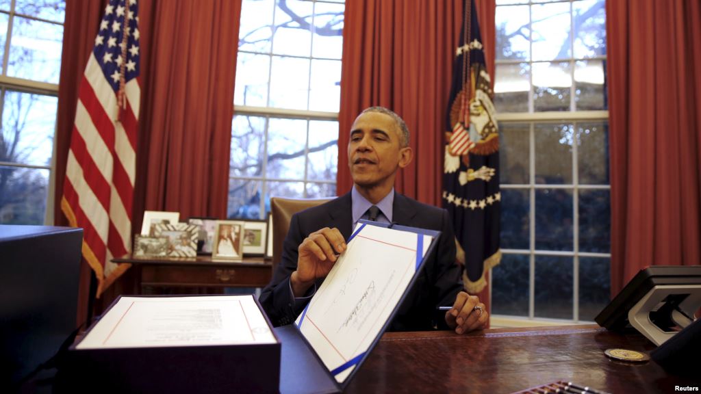 US President Barack Obama reacts as after signing the $1.1 trillion Government Funding Bill into Law at the Oval Office of the White House in Washingt