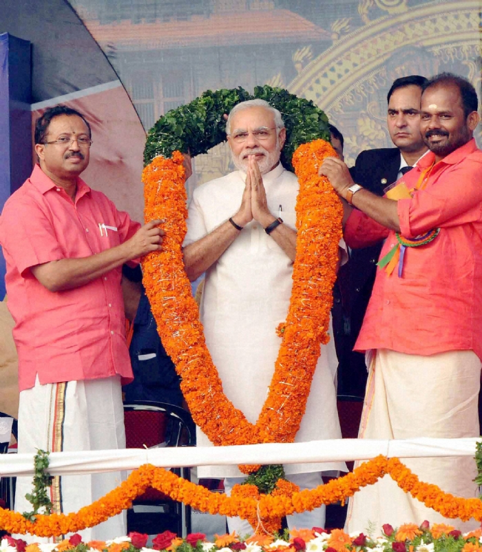 PM Narendra Modi is garlanded during a public meeting in Thrissur Kerala on Monday