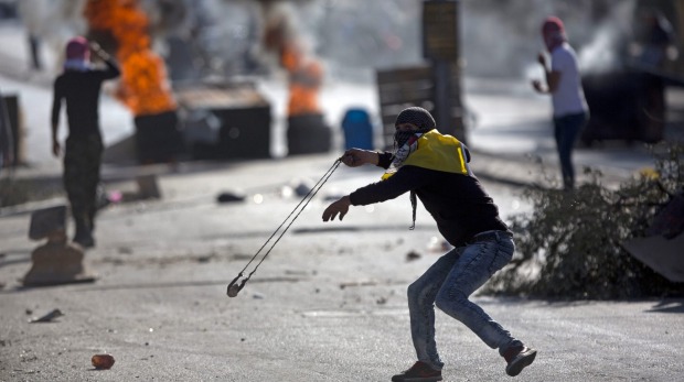 Palestinian protesters hurl stones at Israeli troops near Bethlehem in the West Bank on December 8