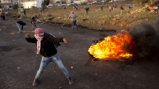 Palestinian protesters throw stones at Israeli troops in the West Bank city of Ramallah on Sunday