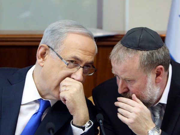 Israel´s Prime Minister Benjamin Netanyahu left speaks with Cabinet Secretary Avichai Mandelblit during the weekly cabinet meeting in Jerusalem Sunday Dec. 20 2015