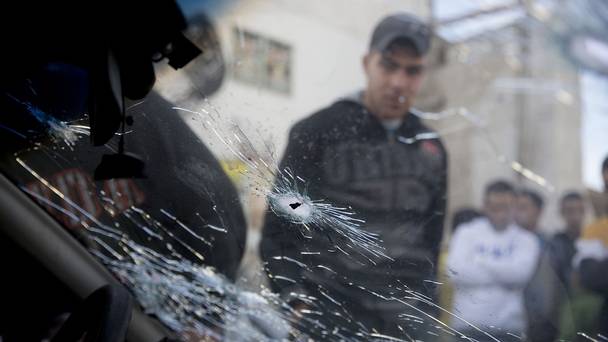 Palestinians a look at a car used in an attempted ramming attack on Israeli soldiers in the Qalandia refugee camp on the outskirts of Ramallah