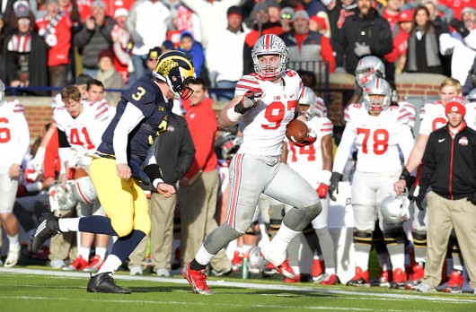 OSU junior defensive end Joey Bosa runs with the football after intercepting a pass in a game against Michigan on Nov. 28 at Michigan Stadium. OSU won 42-13. Credit Samantha Hollingshead