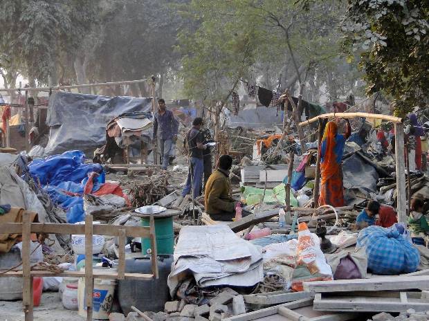 People collect their belongings after a demolition drive carried out by railways in Shakur Basti of Delhi