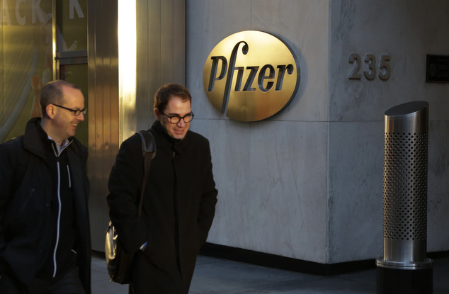 Men pass Pfizer's world headquarters Monday Nov. 23 2015 in New York. Pfizer and Allergan will join in a $160 billion deal to create the world's largest