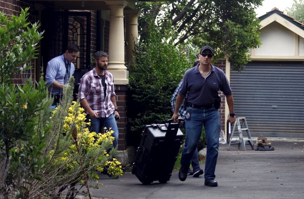 Australian Federal Police officers walk down the driveway after searching the home of probable creator of cryptocurrency bitcoin Craig Steven Wright in Sydney's north shore