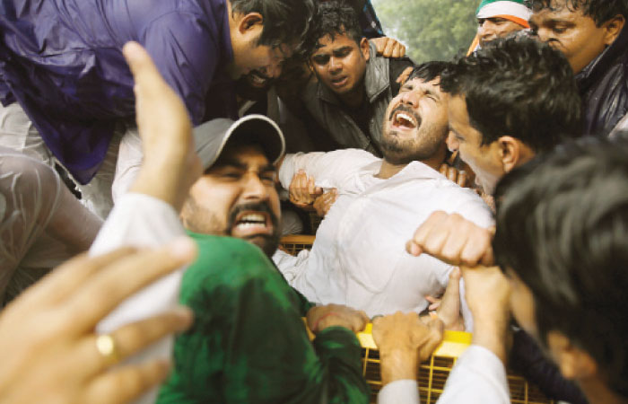 A Youth Congress leader grimaces in pain as he got entangled in police barricade during a demonstration against what they call growing intolerance in the country in New Delhi India Monday in this file