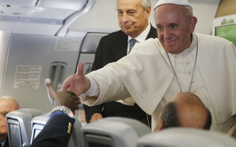 Pope Francis greets a journalist aboard his flight from Bangui Central African Republic to Rome on Monday