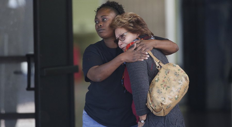 Two women embrace at a community center where family members are gathering to pick up survivors after a shooting rampage that killed multiple people and wounded others at a social services center in San Bernardino Calif