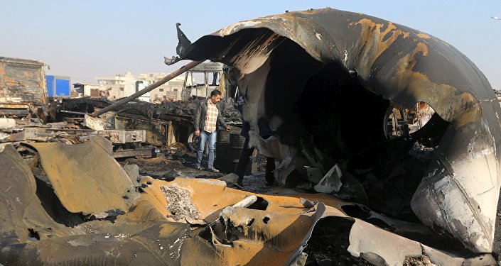 A man inspects the damage after what activists said were air strikes carried out by the Russian air force on a parking garage for cargo trucks in al Dana town near the Syrian Turkish border in Idlib Governorate