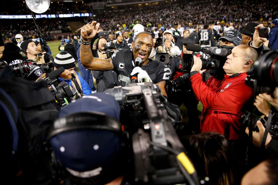 Raiders safety Charles Woodson addresses the Oakland crowd after Thursday night's overtime victory. He is retiring after 18 seasons in the NFL