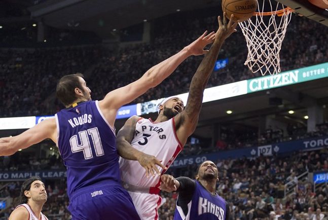 Toronto Raptors forward James Johnson drives to the hoop through stiff defence from Sacramento Kings centre Kosta Koufos and forward Rudy Gay during first half NBA action in Toronto Sunday December 20,2015. THE CANADIAN PRESS  Frank Gunn