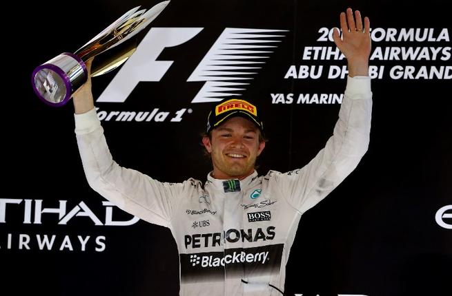 Mercedes AMG Petronas F1 Team's German driver Nico Rosberg celebrates on the podium at the Yas Marina circuit in Abu Dhabi