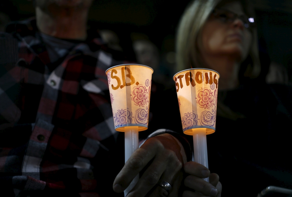 Attendees hold candles with a hand written message as they reflect on the tragedy of Wednesday's attack during a candlelight vigil in San Bernardino California. The Dec. 3 shooting in San Bernardino threw politicians off their talking points as more