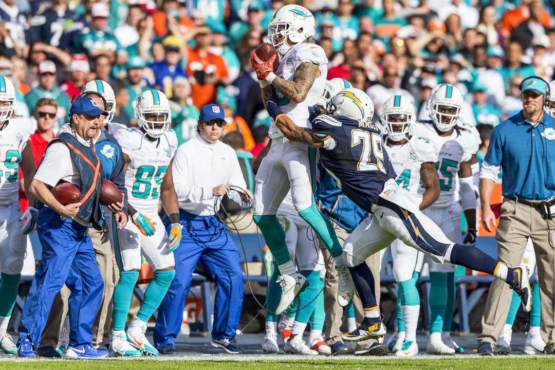 San Diego Chargers cornerback Craig Mager pushes a Miami Dolphins receiver out of bounds in front of the Dolphins bench