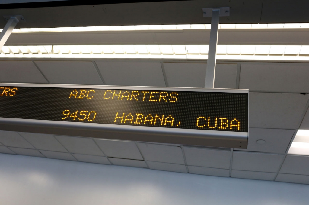 A sign indicates the ABC Charters American Airlines flight to Havana Cuba at Miami International Airport