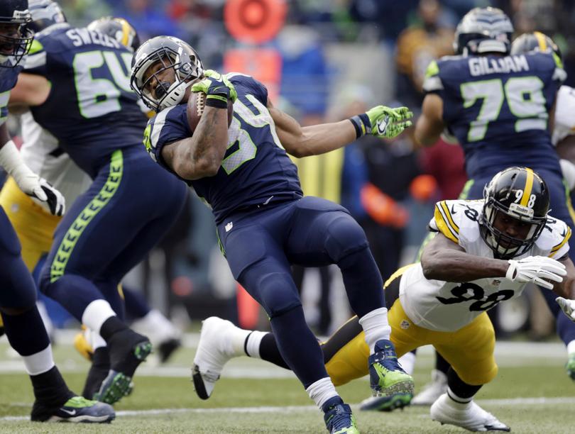 Seahawks Thomas Rawls left rushes past Pittsburgh Steelers Vince Williams in the first half of Sunday’s game