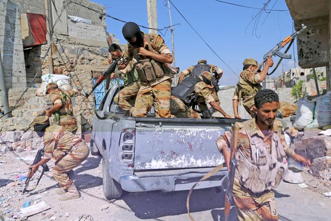 Soldiers loyal to Yemen’s government jump off a truck during a training exercise in the country’s southwestern city of Taiz on Sunday