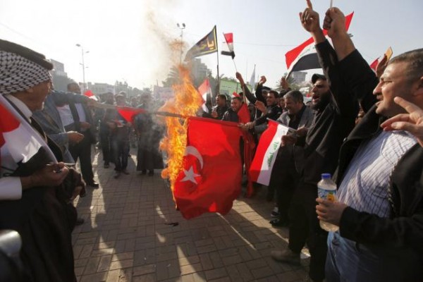 Protesters burn a Turkish national flag during a demonstration against the Turkish military presence in Iraq at Tahrir Square in central Baghdad Iraq