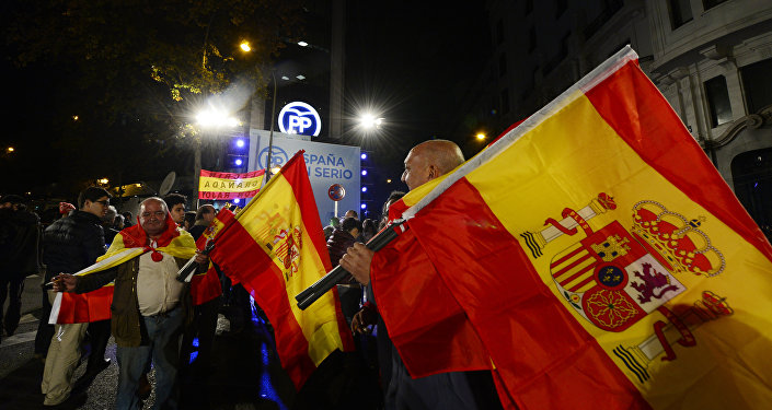 Popular Party supporters wave Spanish flags in front of the party's headquarters after the partial results of Spain's general elections in Madrid