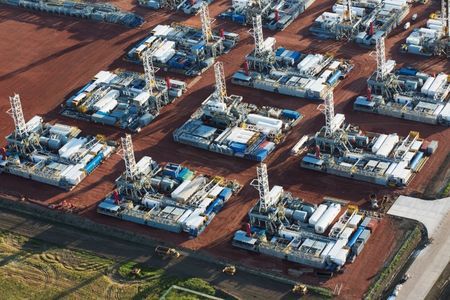 Stacked rigs are seen along with other idled oil drilling equipment at a depot in Dickinson