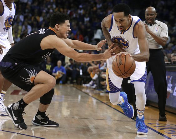 Shaun Livingston right drives the ball against Phoenix Suns Devin Booker during the first half of an NBA basketball game Wednesday Dec. 16 2015 in Oakland Calif