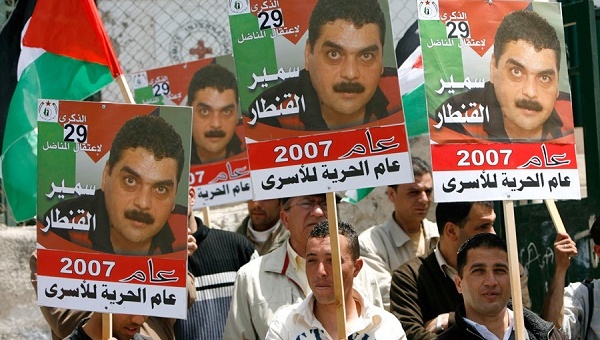 Supporters hold signs of Samir Qantar in this file