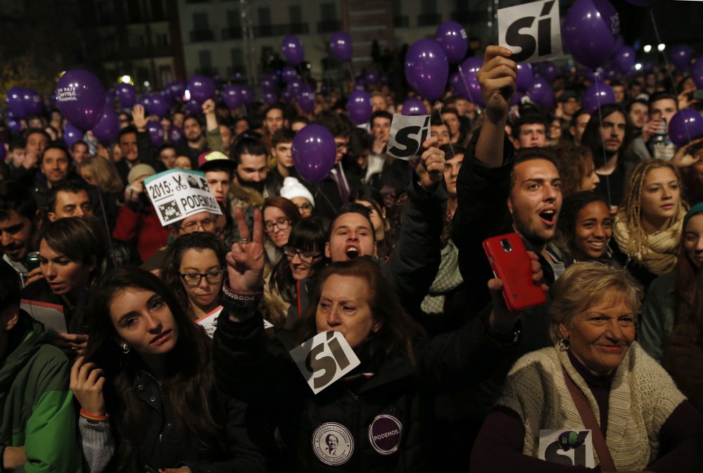 Supporters of the Podemos party wait for official results in Madrid on Sunday