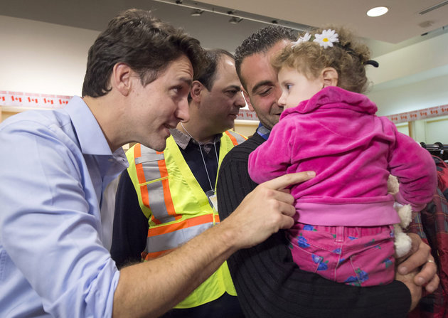 Syrian refugees arriving by government plane are en route to Canada