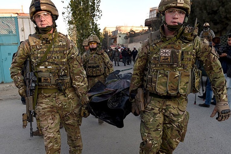 Afghan security forces stand guard near a terrorist attack site close to the Spanish embassy in the center of Kabul Afghanistan Friday Dec. 11 2015. An Afghan official says a car bombing near a foreign guesthouse in central Kabul has wounded one per