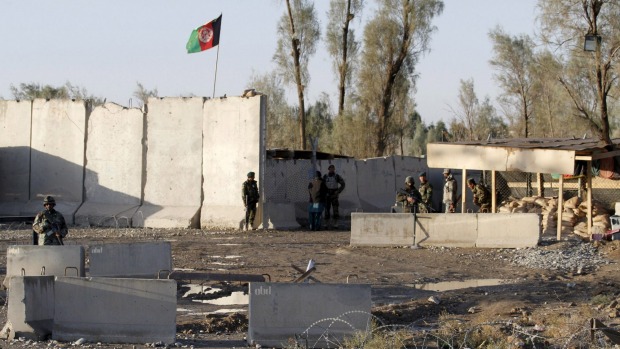 Afghan security forces stand guard at the entrance gate of Kandahar Airport where Taliban stormed killing and wounding an unknown number of people