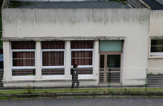 A police officer walks in front of the building of Jean Perrin nursery school in Aubervilliers a suburb northeast of Paris where a teacher was attacked in the morning by a man wielding a box cutter and scissors who cited the Islamic State jihadist group