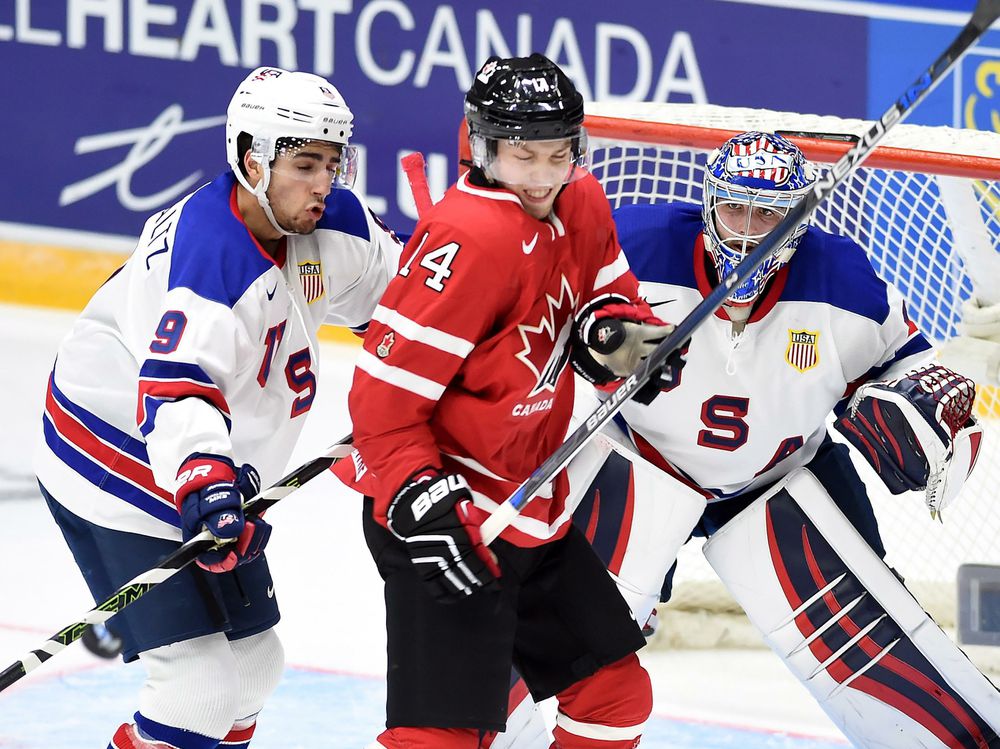 Canada's Rourke Chartier takes a shot from a teammate as the United States&#039 Nick Schmaltz tries to check him away from the crease during second period preliminary hockey action at the IIHF World Junior Championship in Helsinki on Saturday