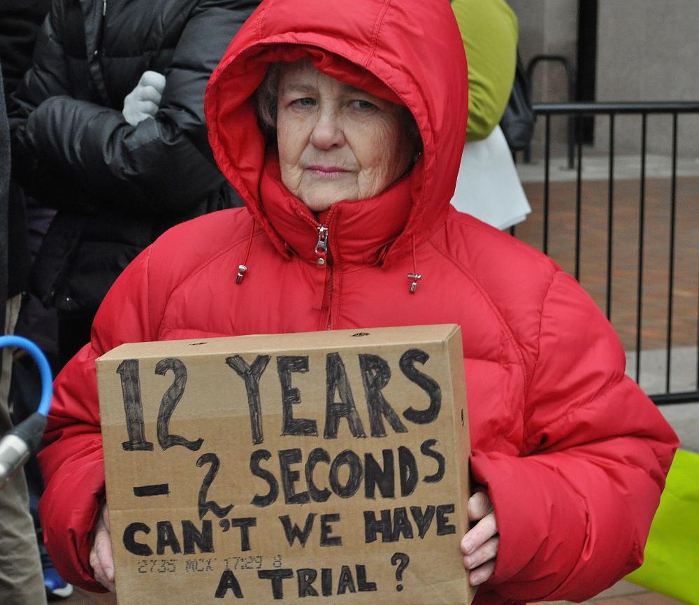 The sign Barbara Wilberg is holding refers to the age of Tamir Rice and the amount of time it took for police to arrive and shoot him