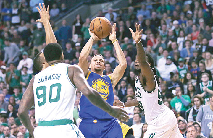 Stephen Curry of Golden State tries to shoot over Boston Celtics forwards Amir Johnson and Jae Crowder during their NBA game Friday in Boston. The Warriors won in double overtime 124-119