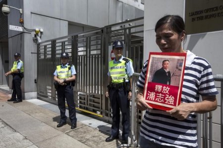 Pro-democracy activist Lui Yuk-lin holds a portrait of Chinese human rights lawyer Pu Zhiqiang during a protest calling for the release of Pu and other political prisoners outside the Chinese liaison office in Hong Kong