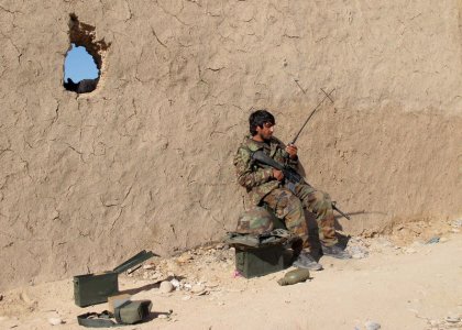 An Afghan National Army soldier speaks on a radio at an outpost in Helmand province