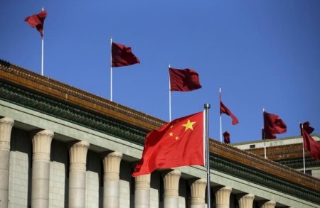 Chinese flag waves in front of the Great Hall of the People in Beijing China