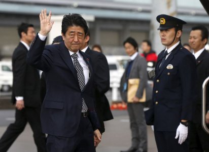 Japan's Prime Minister Shinzo Abe waves as he departs for India at Tokyo's Haneda airport Japan